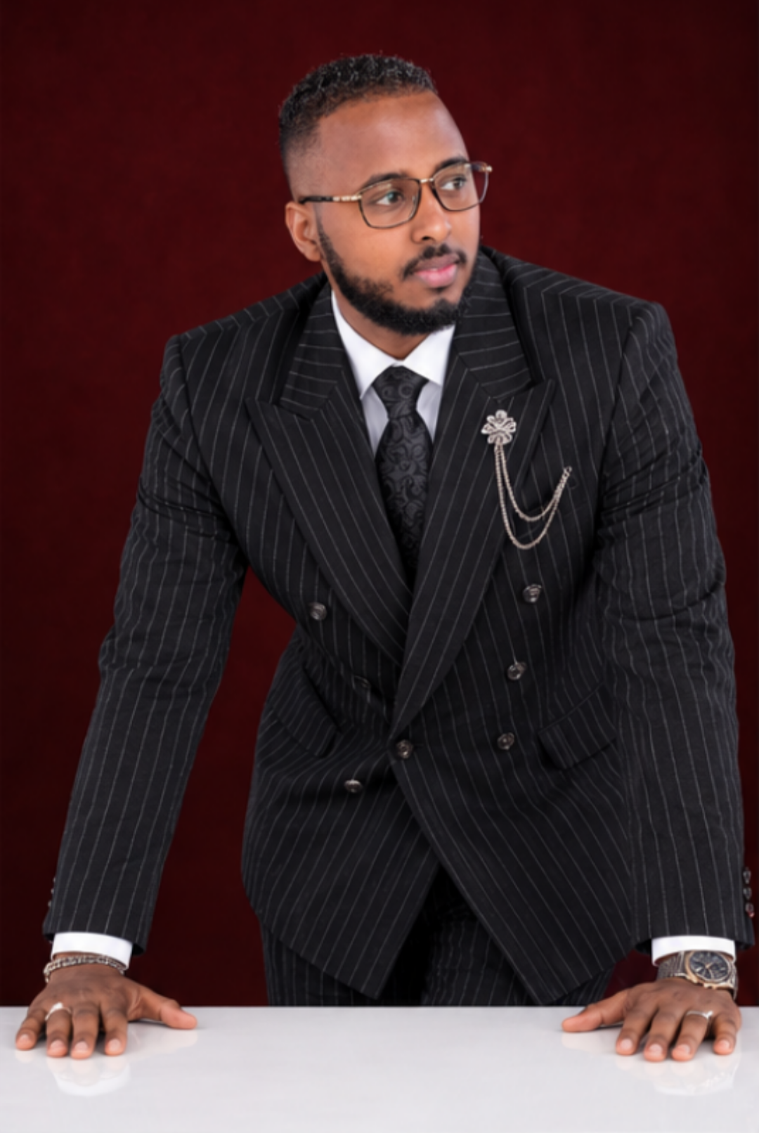 Black pinstripe double-breasted suit styled with a tie and lapel detail
